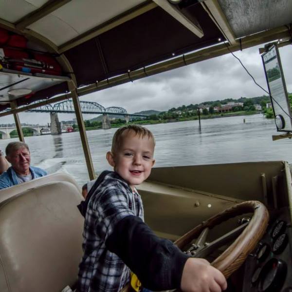 child driving duck boat