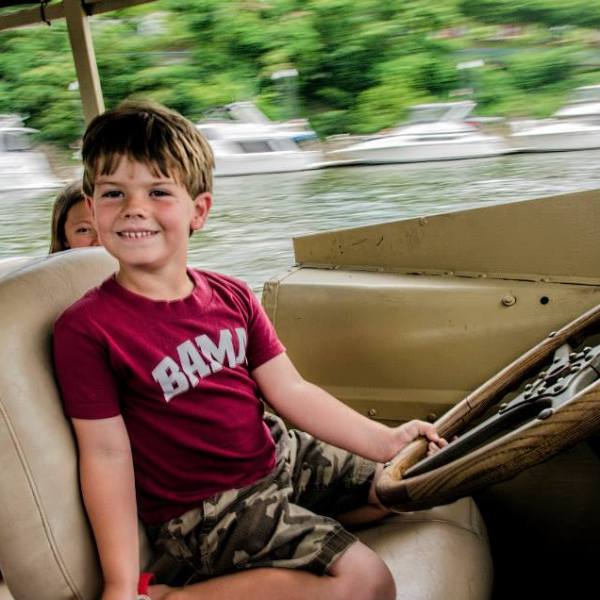 child driving boat